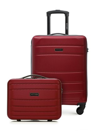 Dwie czerwone walizki o twardej powłoce, jedna duża z wysuwanym uchwytem i kółkami, oraz jedna mniejsza w stylu torebki, obie oznaczone marką "WITTCHEN".