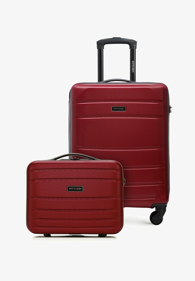 Zwei rote Hartschalenkoffer, einer groß mit ausziehbarem Griff und Rollen, und eine kleinere Handtaschen-ähnliche Tasche, beide mit dem Aufdruck "WITTCHEN".