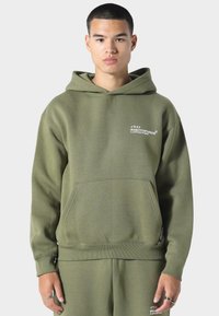 Oliivinvihreä huppari pehmeästä kankaasta, jossa on etutasku, ribattu hihansuu ja logo painettuna rintaan. Klassinen hupparimuotoilu.