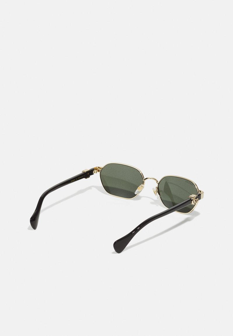 Gold-framed sunglasses with green lenses. Octagonal shape with black temple arms. Notable gold hardware accents near the hinges.