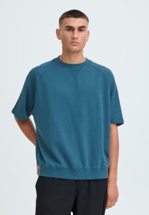 Türkiser Kurzarm-Sweatshirt mit einem gerippten Rundhalsausschnitt, Raglanärmeln und einer lockeren Passform. Hergestellt aus einem weichen Baumwollmix.