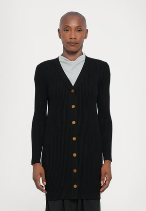 Cardigan noir côtelé avec un col en V, des manches longues et sept boutons dorés sur le devant. Texture douce, design arrivé au genou.