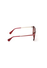 Gafas de sol rojas y carey con un acabado brillante, acentos metálicos y patillas cónicas. La forma de la montura es ligeramente de ojo de gato con una textura suave.