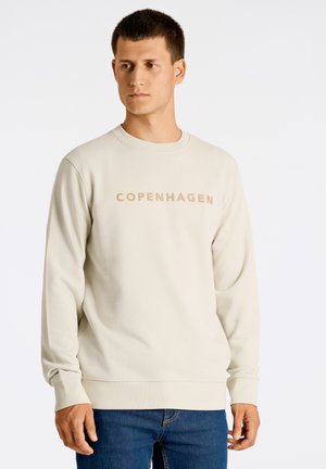 Sweatshirt beige clair avec un col rond, des manches longues et un texte en contraste "COPENHAGEN LINDBERGH" sur le devant.