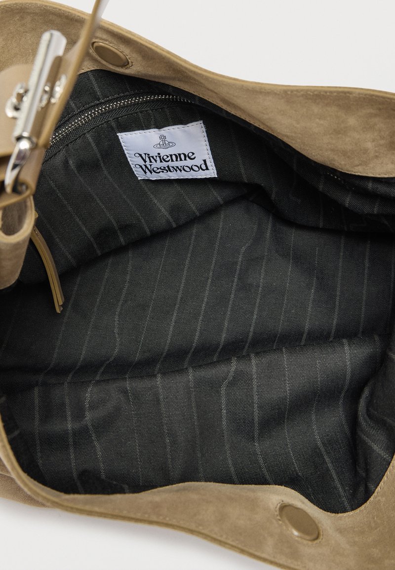 Handbag interior with black pinstripe fabric lining and a white Vivienne Westwood brand label sewn inside.