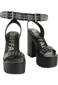 Svarta plattformssandaler med en bred rem med silveröglor, justerbar ankelsnodd och tjock klack. Logotyp tryckt på innersulan.
