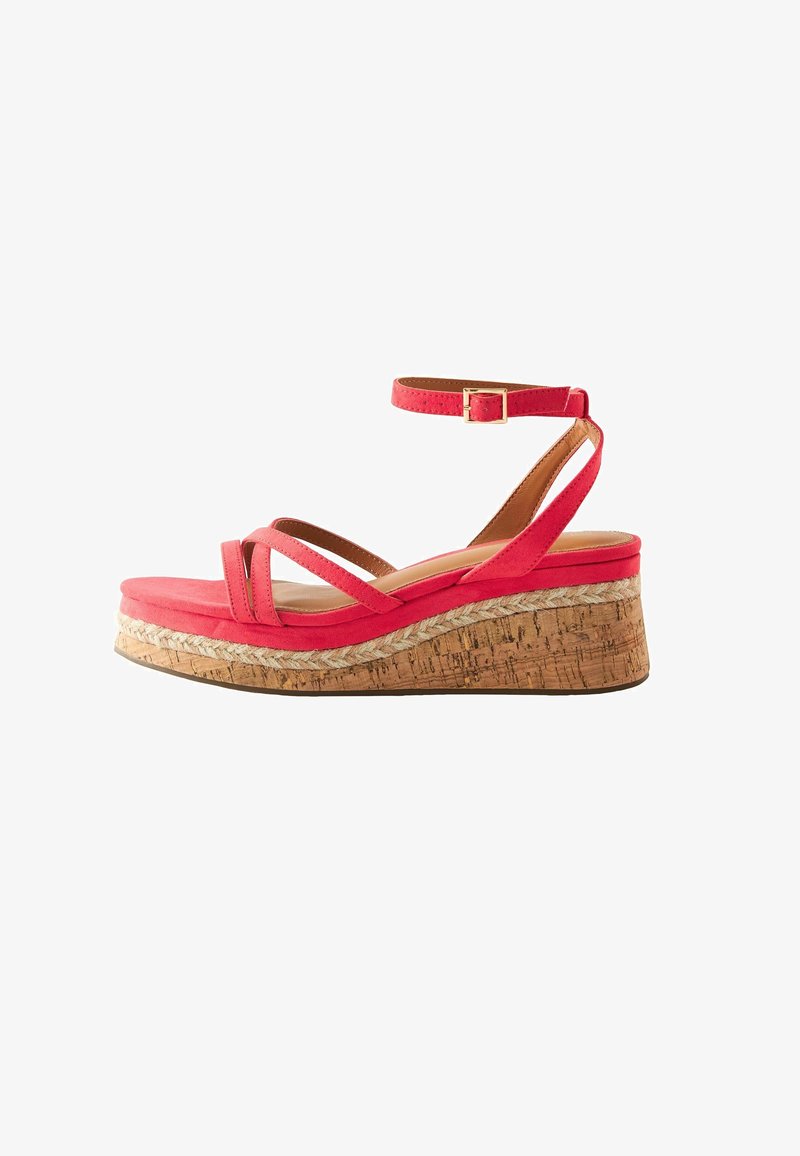 Sandale rouge à talon en liège, détail tressé, double lanières avant et bride de cheville avec boucle dorée.