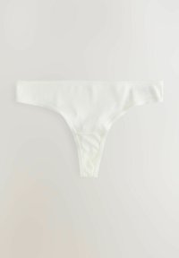 String en coton blanc avec une texture lisse, des bretelles latérales étroites et un bord festonné. Design simple sans embellissements.