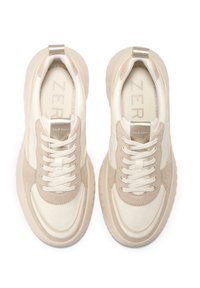 Ein Paar beige und weiße Cole Haan Sneakers mit Schnürsenkeln, dicken Sohlen und markenbeschrifteten Einlegesohlen, von oben auf einem weißen Hintergrund betrachtet.