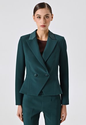 Blazer doppiopetto teal in tessuto strutturato con vita a peplo, colletto stondato e pantaloni coordinati, caratterizzati da linee pulite e bottoni.