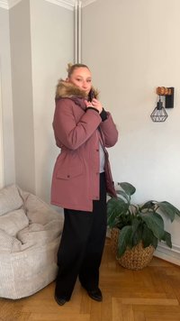 Bordó bélelt télikabát prémmel bélelt kapucnival, cipzáras és patentos záródással, két elülső zsebbel és alakot formáló megkötővel a deréknál.