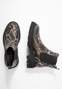 Botas Chelsea con estampado de serpiente en tonos beige y negro, con paneles laterales elásticos y suelas de goma gruesas y texturizadas para mayor tracción.