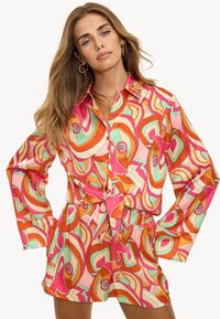 Vestido camisería colorido y estampado, con motivos en espiral en naranja, rosa y verde menta. Fabricado en una tela suave, con cintura ajustable y cierre de botones en la parte delantera.