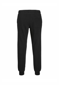 Schwarze Baumwoll-Jogginghosen mit elastischem Bund, gerippten Bündchen und einer einzelnen Gesäßtasche. Glatte Textur und taillierte Passform.