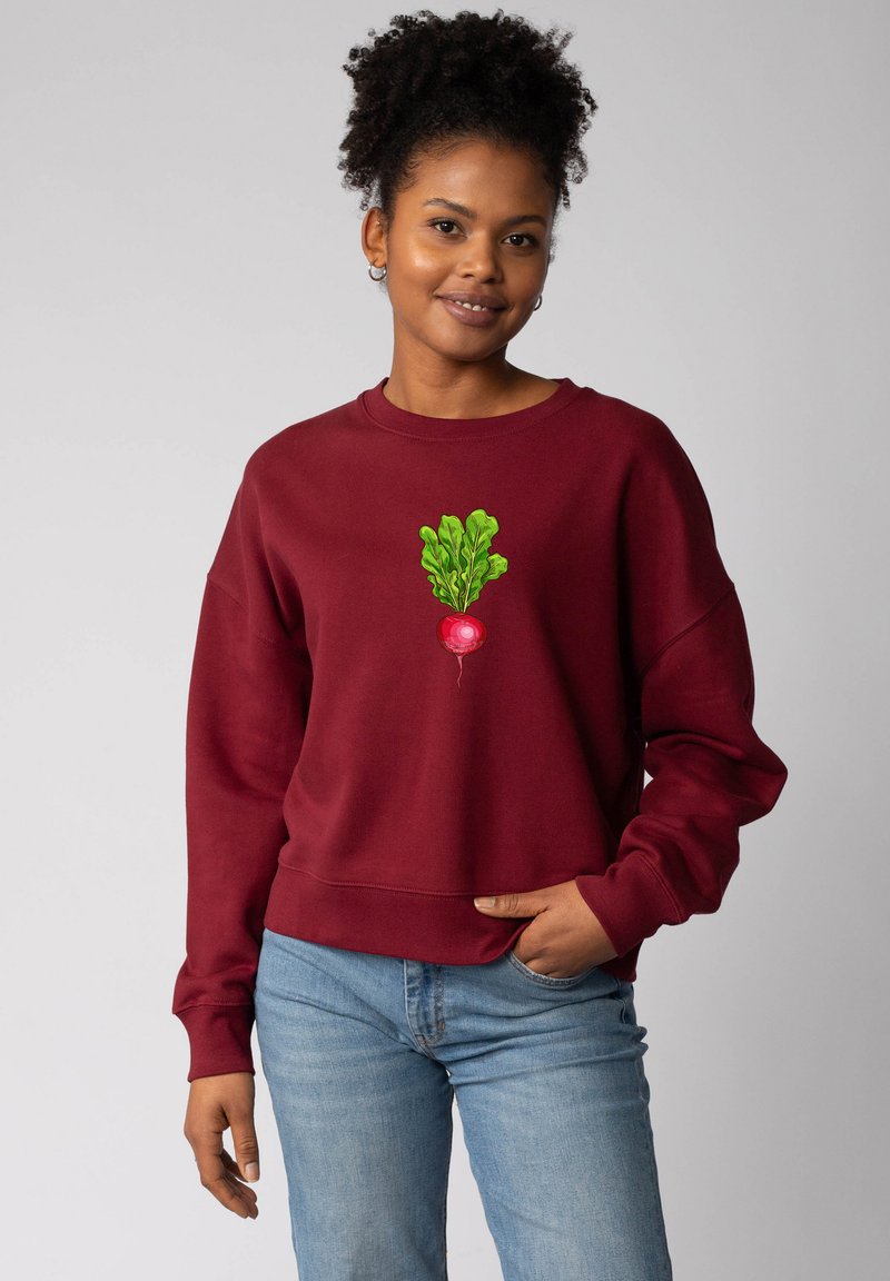 Sweatshirt bordeaux avec des poignets et un ourlet côtelés, présentant un motif de radis vert brodé au centre. Texture douce, coupe décontractée.