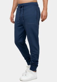 Marineblauwe sweatpants van een katoenmengsel, met een elastische tailleband en koord, gestreepte enkels en subtiele geborduurde logodetails.