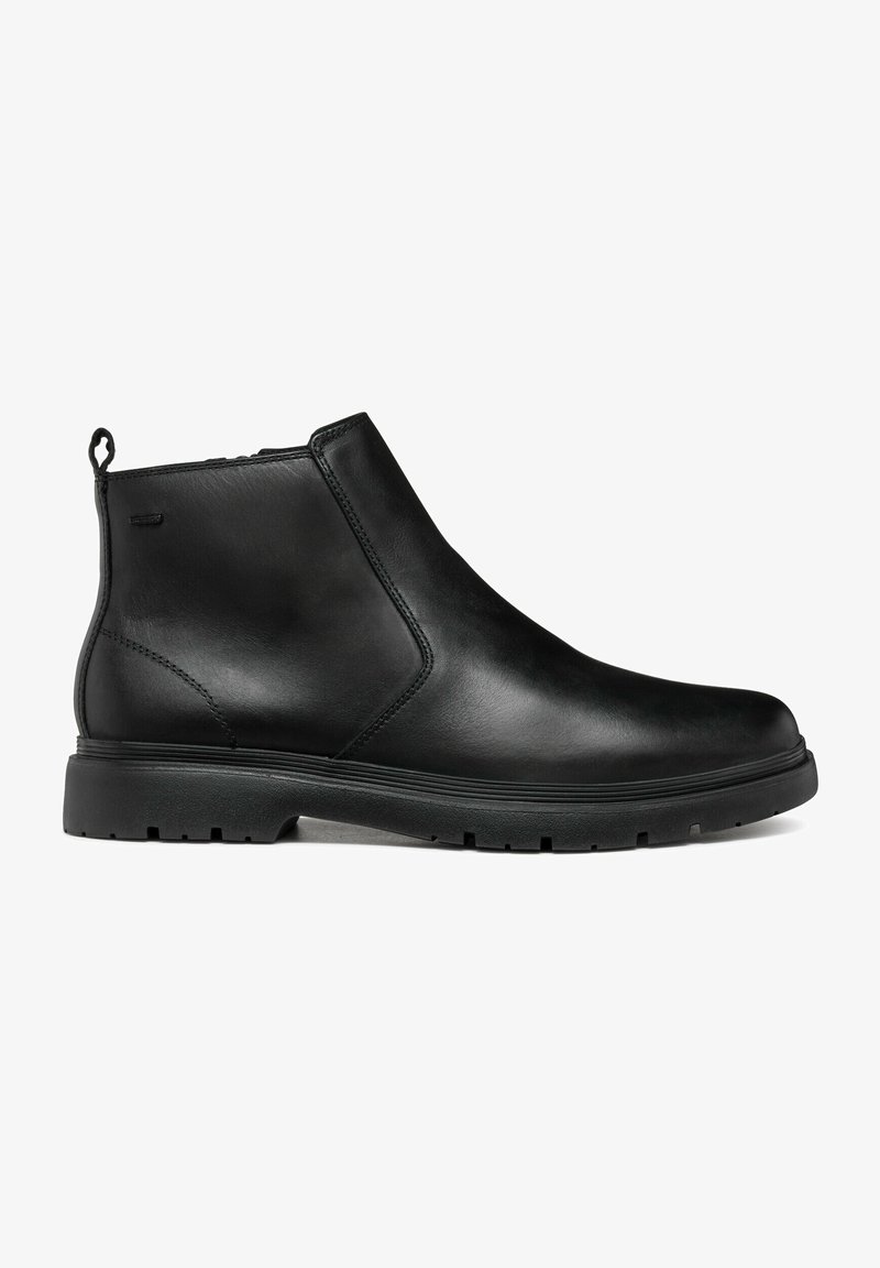 Bottine noire en cuir avec fermeture éclair latérale, languette au talon et semelle en caoutchouc épaisse avec motif de bande de roulement pour une meilleure adhérence.