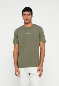 Oliwkowa koszulka z krótkim rękawem wykonana z bawełny, z okrągłym dekoltem i małym, jasnym logo "BOSS" na piersi.