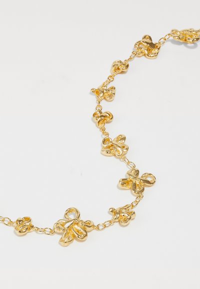 Goldkette mit strukturierten floralen Designs, die durch kleine Ketten verbunden sind, mit glänzender Oberfläche und detaillierter Verarbeitung.