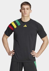 Zwarte sport t-shirt met korte mouwen, met groene, gele en rode strepen op de linkerschouder. Adidas-logo in goud op de borst.