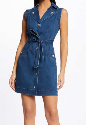 Denimjurk in diepblauw, mouwloos ontwerp, met kraag en knoopsluiting aan de voorkant, getailleerde taille met ceintuur. Heeft goudkleurige knopen en zakken.
