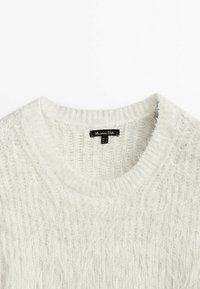 Pull en tricot blanc avec un col rond, présentant une surface douce et texturée. L'étiquette indique "Massimo Dutti", précisant la marque d'origine.