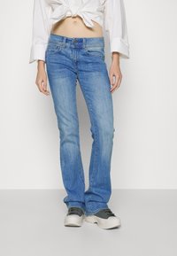 Jeans de mezclilla azul claro con un diseño de pierna recta, lavado medio, estilo de cinco bolsillos y cierre de botón metálico. Presentan un ligero desgaste y desvanecimiento.