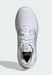Scarpa sportiva bianca con tomaia in rete testurizzata, lacci piatti e collare imbottito. Presenta una striscia grigia e un marchio sul lato e sulla linguetta.