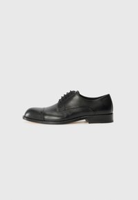 Black leather dress shoe with a rounded toe and smooth finish. Features laces, minimal stitching, and a low stacked heel.
