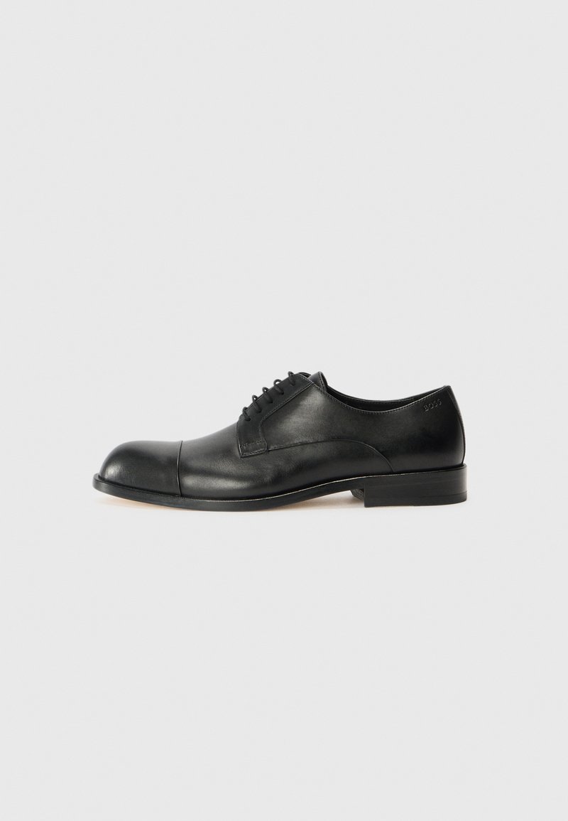 Black leather dress shoe with a rounded toe and smooth finish. Features laces, minimal stitching, and a low stacked heel.