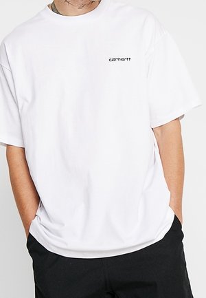 Biała bawełniana koszulka o luźnym kroju, z okrągłym dekoltem, krótkimi rękawami i małym czarnym logo na lewej piersi. Gładka faktura.