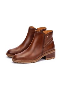 Brown leather ankle boots featuring a smooth finish, a braided accent on the side, and a sturdy, textured sole with a low heel.
