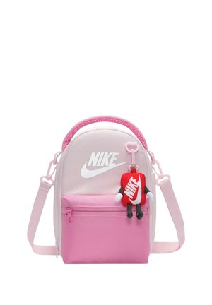 Piccola borsa a tracolla Nike rosa e bianca con tasca frontale con cerniera e portachiavi di peluche Nike rosso attaccato.