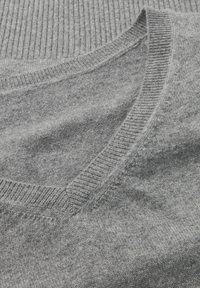 Grauer Strickpullover mit V-Ausschnitt, geripptem Kragen und glatter Textur mit einem dezenten Muster.