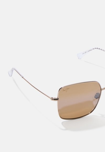 Sonnenbrille mit braun getönten Gläsern, Metallrahmen und klaren, strukturierten Ohrpolstern. Quadratische Form mit minimalistischem Design.