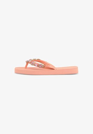 Sandalia flip-flop de color coral rosa con decoraciones de piedras preciosas rosas y doradas en las correas, suela plana acolchada, aislada sobre fondo blanco.
