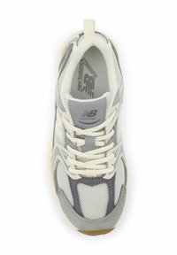 Zapatilla de correr en gris y blanco con parte superior de malla, detalles de ante y suela de goma texturizada. Presenta un diseño en capas y cordones para un ajuste seguro.