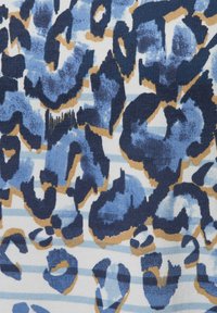 Leopardenmusterstoff mit blauen und marineblauen Flecken sowie beigen Akzenten auf einem weißen gestreiften Hintergrund; gerippte Textur; weiches Material.