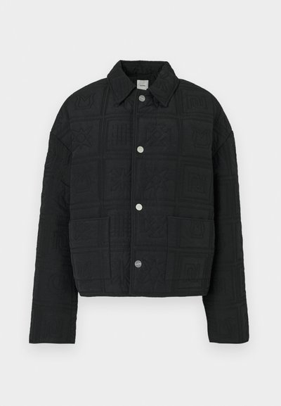 Must pehmeast materjalist tehtud musta õmmeldud jope, millel on lühike lõige, topeltrinnataskud ja dekoratiivsed sissepressitud mustrid, hõbedased nöpsuknad.