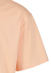T-shirt à manches courtes en tissu pêche doux, avec une coupe décontractée, une texture lisse et un ourlet propre le long du bas.