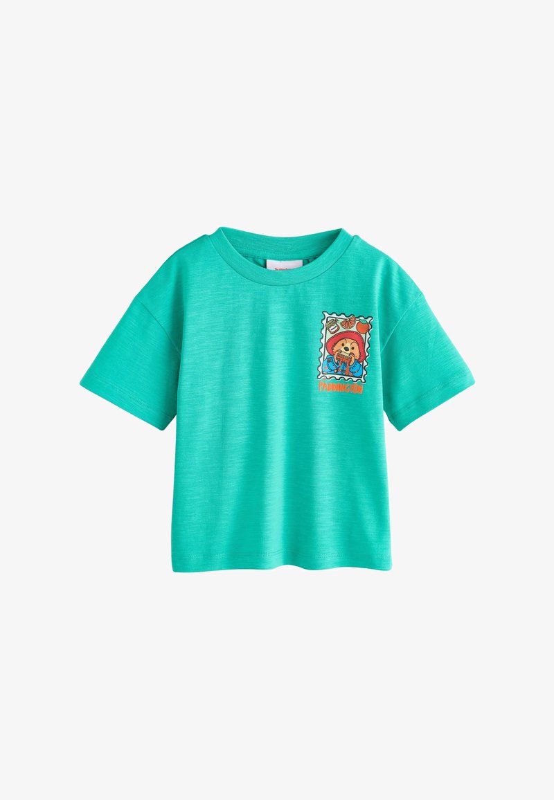 Camiseta de manga corta color turquesa con un estampado de Paddington Bear comiendo un sándwich en el lado izquierdo del pecho.