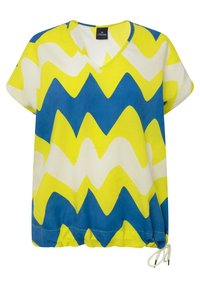 Løs V-hals bluse med et zigzag-mønster i gul, blå og hvid. Lavet af letvægtsstof med en snøre i kanten.