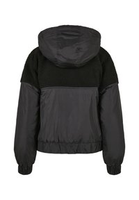 Sort hettejakke med en lodden øvre del og en glatt, kontrasterende nedre del. Elastiske mansjetter og midjebånd for en tett passform.