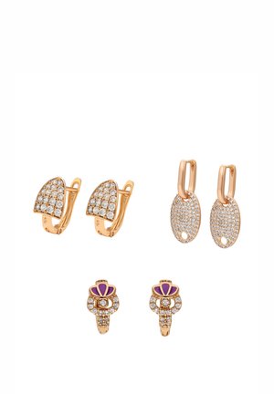 Drie paar gouden oorbellen: een halve cirkel met heldere stenen, een ovale druppel met geperforeerd detail en heldere stenen, en een bloemmotief met paarse accenten.