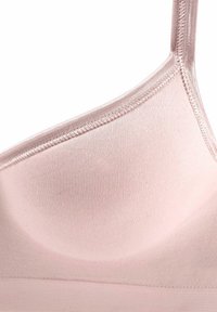 Bonnet de soutien-gorge rose clair sans coutures avec tissu lisse et bretelle fine réglable, mettant en valeur les détails de couture.