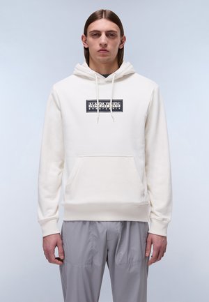 Witte hoodie met een voorzak, een capuchon met trekkoord en een zwart grafisch logo. Effen stofstructuur, ribgebreide manchetten en zoom. Gecombineerd met grijze cargobroek.
