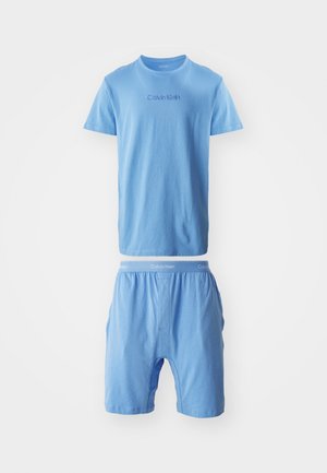 Svetlomodré bavlnené tričko a zodpovedajúce boxerky. Tričko má logo Calvin Klein, zatiaľ čo boxerky majú elastický pás s logom.