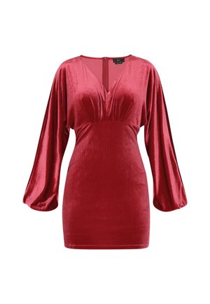 Crvena baršunasta haljina s V-izrezom, naboranim gornjim dijelom i dugim napuhanim rukavima. Ima patentni zatvarač na sredini leđa i gladak materijal.