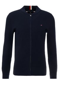 Tyrkysový pletený kardigan s předním zipem, přízí s žebrovým límcem a manžetami. Obsahuje malé logo a texturovanou tkaninu. Akcentové barvy jsou bílá a červená.