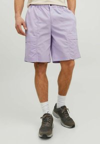 Lavender cargo shorts with an elastic waistband, side pockets, and a relaxed fit, made from lightweight fabric. Worn with dark sneakers.